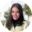 A woman with long black hair smiling in an outdoor environment.