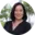 Smiling woman in black blouse with trees in background