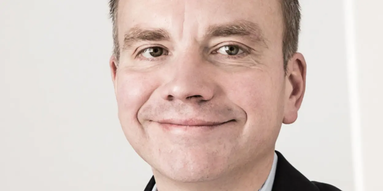 Man in a suit smiling at the camera