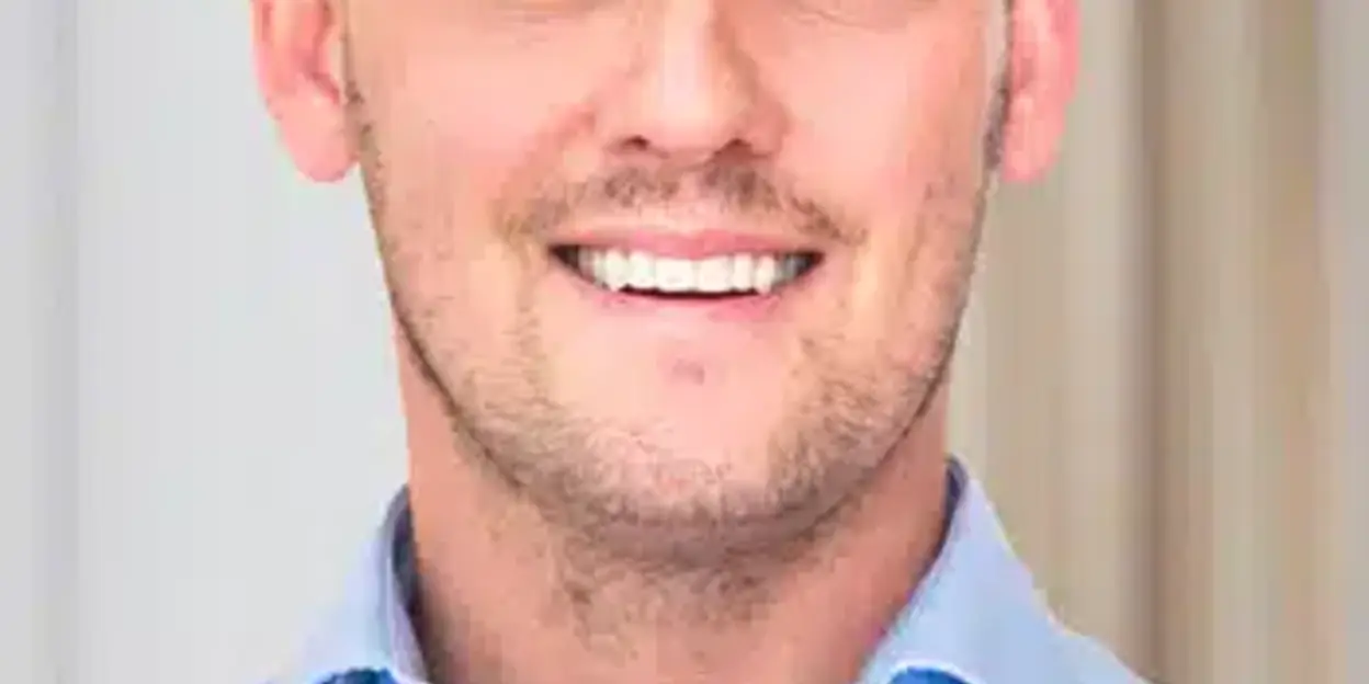 Man with a smile wearing a light blue shirt