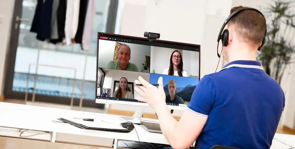 Person on headset video conferencing on large monitor