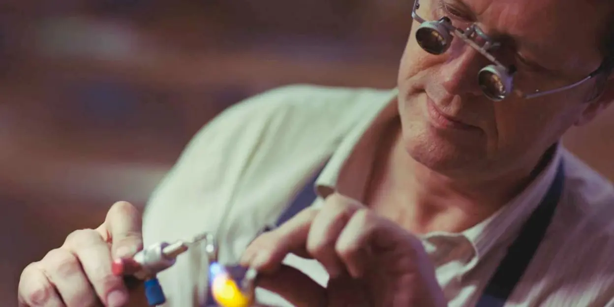 Close-up of an artisan using magnifying glasses for detailed work