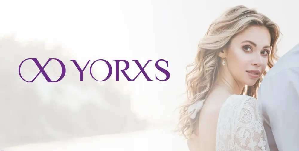 A woman in a lace dress standing beside a YORXS logo