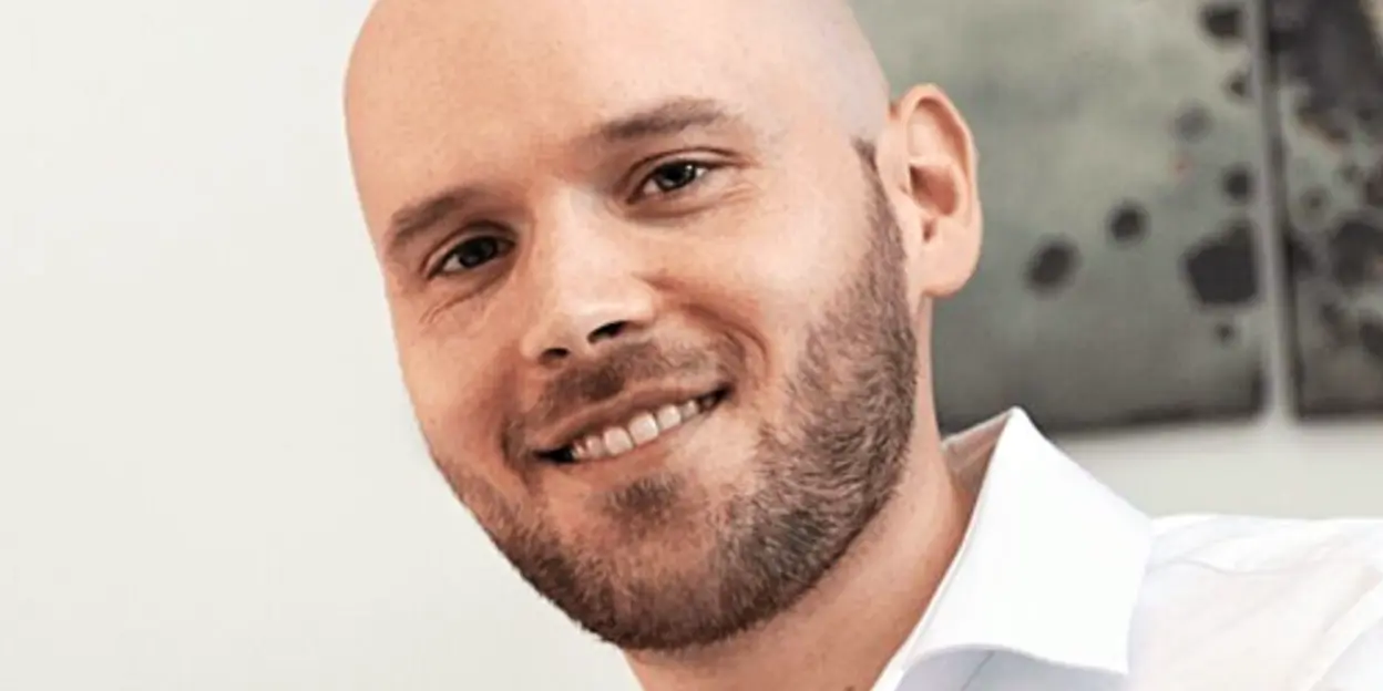 Smiling man in white shirt with beard
