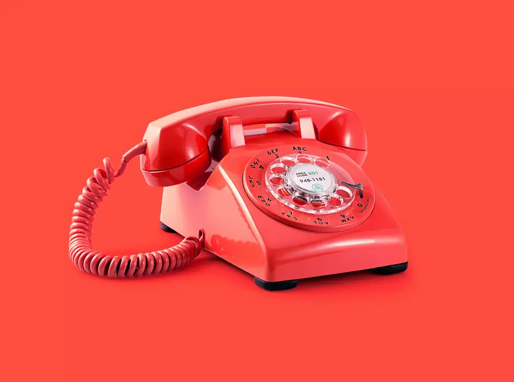 Red rotary telephone on a red background